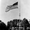 <p>Raising the flag on Fort Slocum&#39;s flagpole, looking north, July 1955. This guyed flagpole was replaced in ca. 1960 by a freestanding monopole.</p>